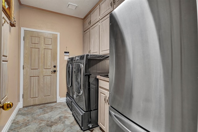 clothes washing area with light tile flooring, crown molding, independent washer and dryer, cabinets, and a textured ceiling