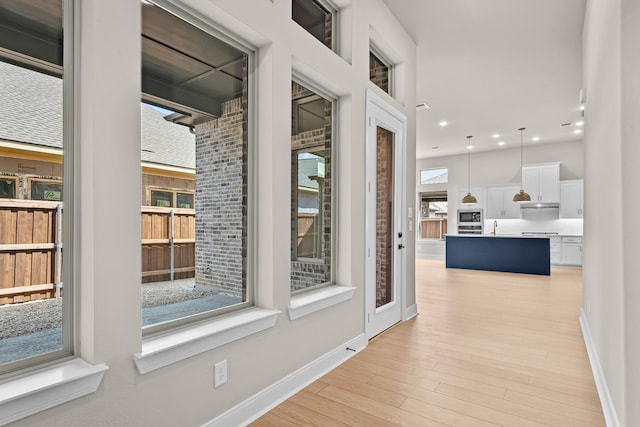 hall with light hardwood / wood-style floors and sink