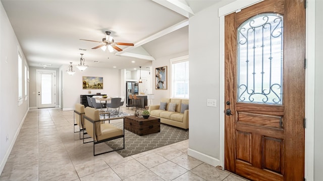 tiled foyer featuring ornamental molding, lofted ceiling, and ceiling fan