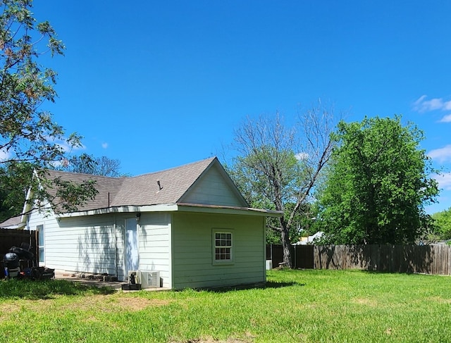 back of house featuring a lawn and central AC unit