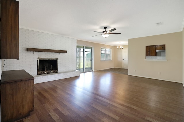 unfurnished living room featuring a brick fireplace, dark hardwood / wood-style floors, and ceiling fan with notable chandelier