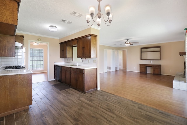 kitchen with dark wood-type flooring, dark brown cabinetry, sink, crown molding, and ceiling fan with notable chandelier