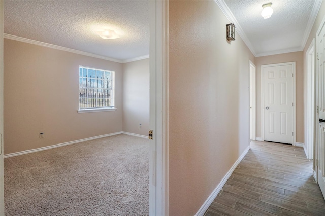 hallway featuring ornamental molding, hardwood / wood-style floors, and a textured ceiling