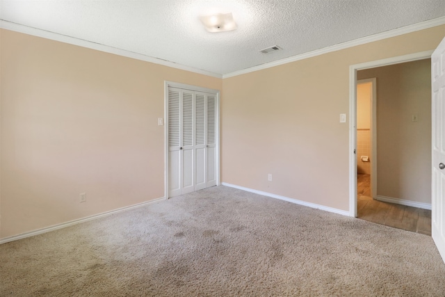 spare room with crown molding, carpet, and a textured ceiling