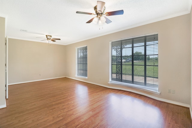 spare room with wood-type flooring, ornamental molding, and a textured ceiling