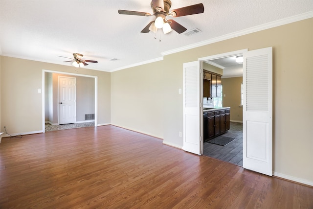 unfurnished room with crown molding, dark wood-type flooring, a textured ceiling, and ceiling fan