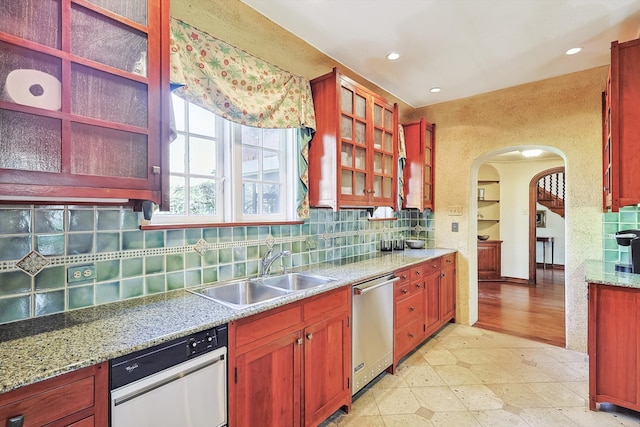 kitchen with light tile patterned flooring, sink, decorative backsplash, and dishwasher