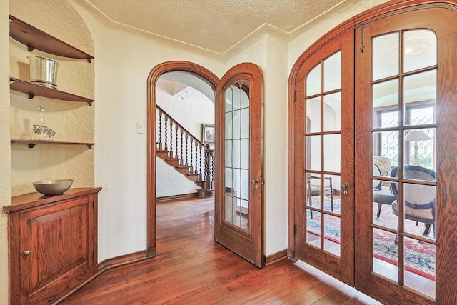 entryway with hardwood / wood-style flooring, french doors, and a textured ceiling