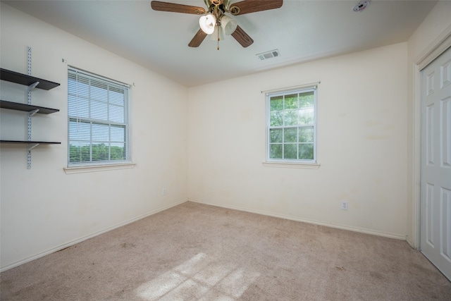 carpeted spare room featuring ceiling fan