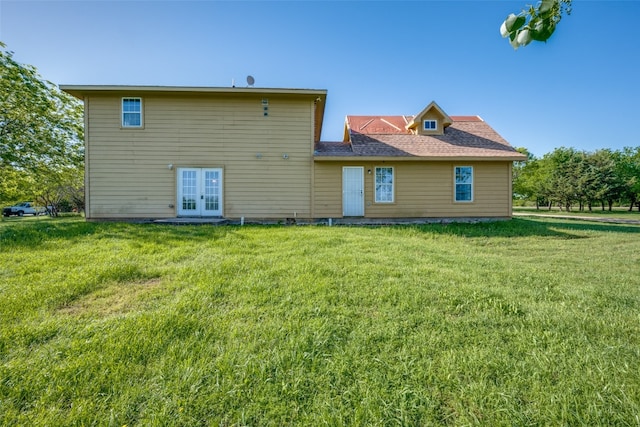 rear view of house featuring french doors and a yard