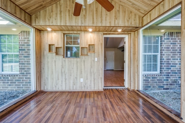 interior space with wood-type flooring, wooden ceiling, vaulted ceiling, and wooden walls