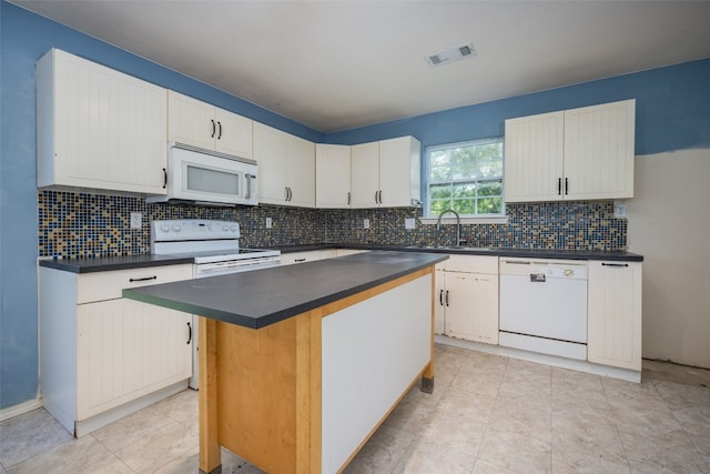 kitchen with a center island, white cabinets, and white appliances