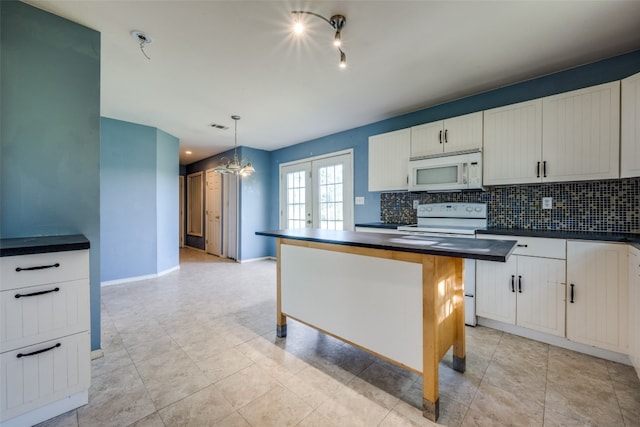 kitchen with white appliances, decorative light fixtures, white cabinetry, and a kitchen island