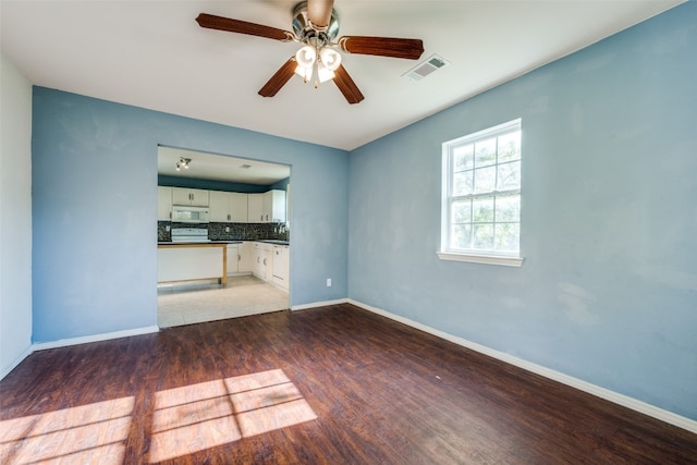 unfurnished living room featuring ceiling fan and dark hardwood / wood-style flooring