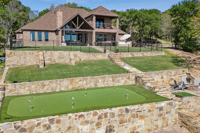 exterior space featuring a chimney, brick siding, a balcony, a fenced backyard, and a patio