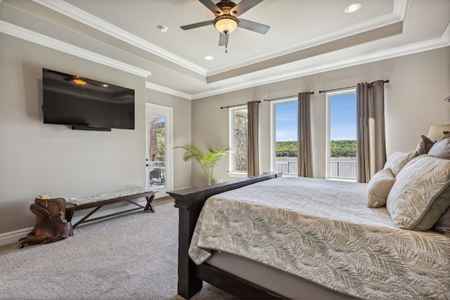 carpeted bedroom featuring ceiling fan, a raised ceiling, and ornamental molding