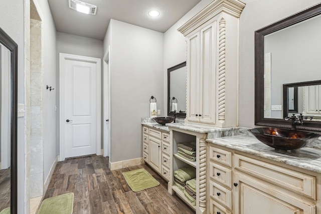 bathroom with wood-type flooring and vanity with extensive cabinet space