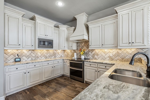 kitchen with sink, stainless steel appliances, white cabinetry, and custom exhaust hood