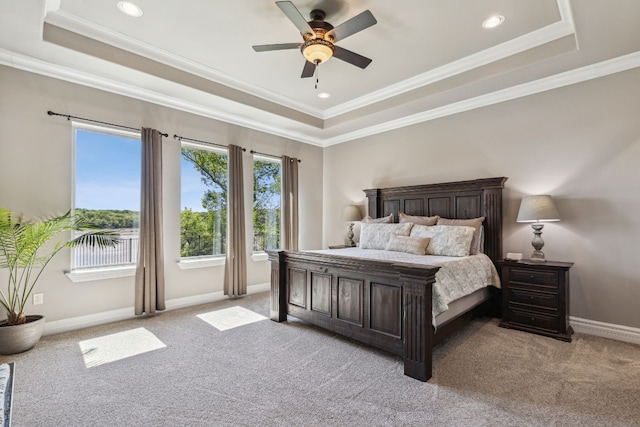 bedroom featuring crown molding, ceiling fan, a raised ceiling, and light colored carpet