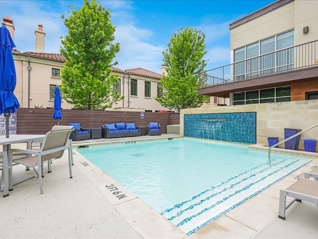 view of pool with a patio area, pool water feature, and outdoor lounge area