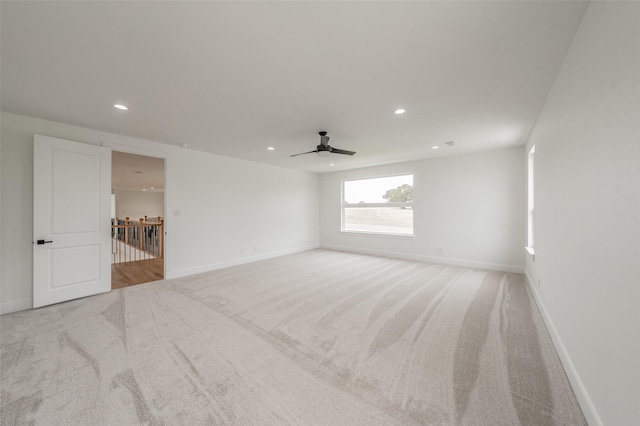 empty room featuring ceiling fan and light colored carpet