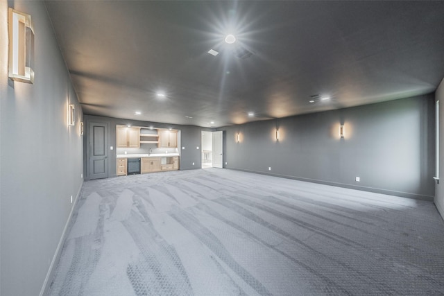 unfurnished living room featuring light colored carpet and sink