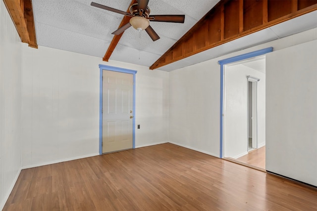 empty room featuring light hardwood / wood-style flooring, a textured ceiling, ceiling fan, and vaulted ceiling