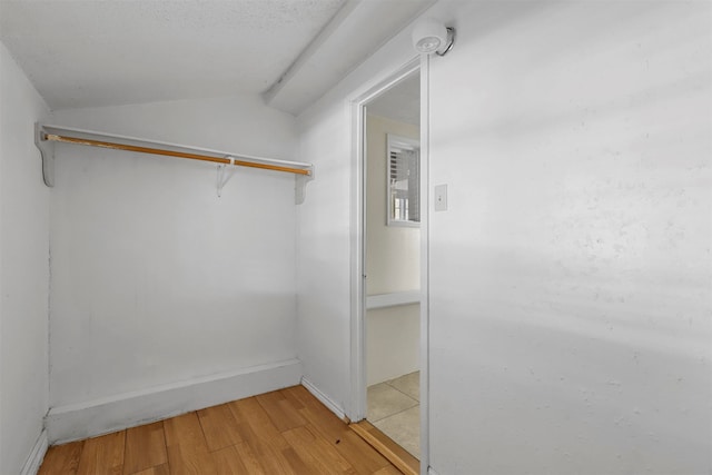 walk in closet featuring light hardwood / wood-style floors and lofted ceiling