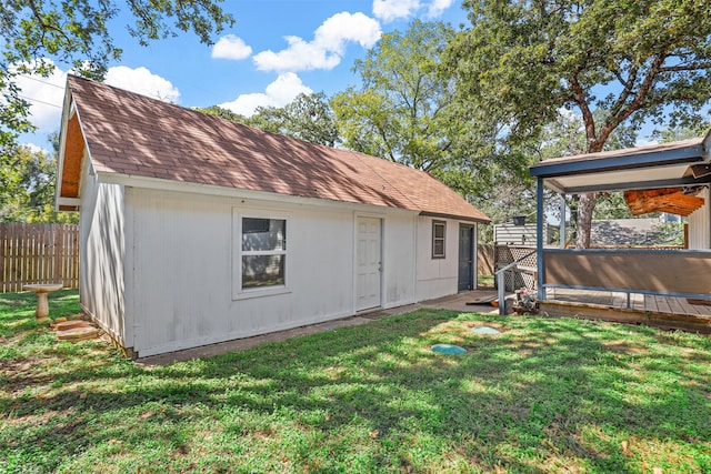 back of property featuring a wooden deck and a lawn