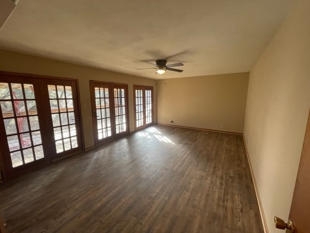 empty room with dark hardwood / wood-style flooring, ceiling fan, and french doors