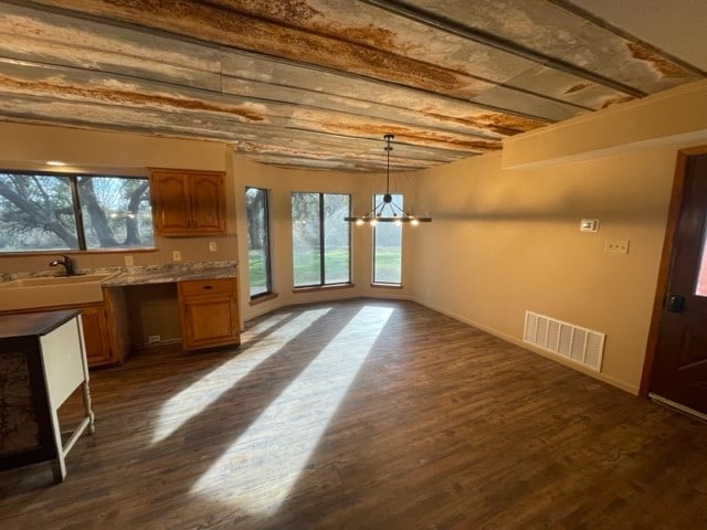 interior space featuring dark wood-type flooring, a wealth of natural light, and a chandelier