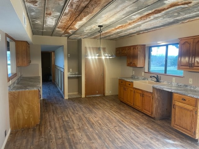 kitchen featuring dark wood-type flooring, sink, and decorative light fixtures