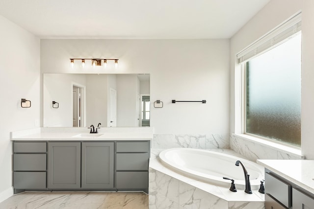 bathroom with vanity, plenty of natural light, and tiled tub