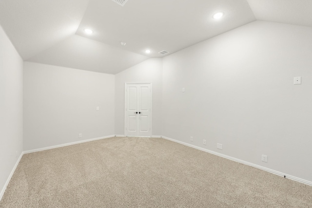 spare room featuring carpet and lofted ceiling