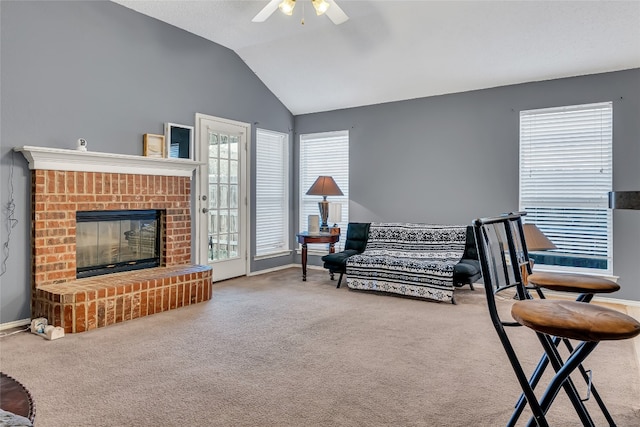 interior space featuring carpet flooring, a fireplace, ceiling fan, and lofted ceiling