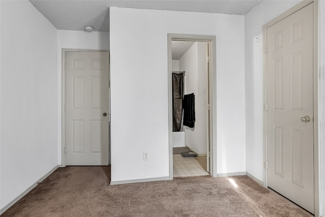 unfurnished bedroom featuring light colored carpet and connected bathroom