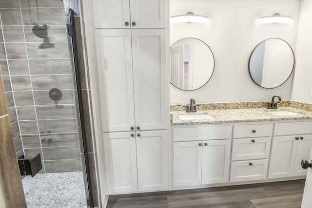 bathroom with vanity, wood-type flooring, and walk in shower