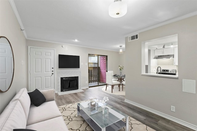 living room featuring crown molding and light hardwood / wood-style flooring