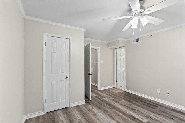 unfurnished bedroom with dark hardwood / wood-style flooring, ceiling fan, and crown molding