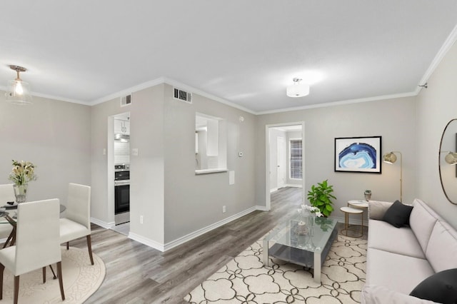 living room featuring ornamental molding and light wood-type flooring