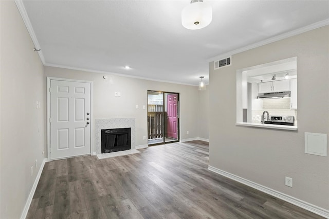 unfurnished living room featuring dark hardwood / wood-style flooring and crown molding