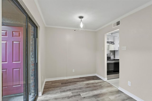 entryway with ornamental molding and light hardwood / wood-style floors