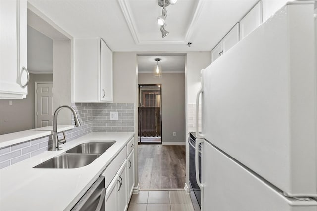 kitchen with white fridge, sink, hanging light fixtures, and white cabinets