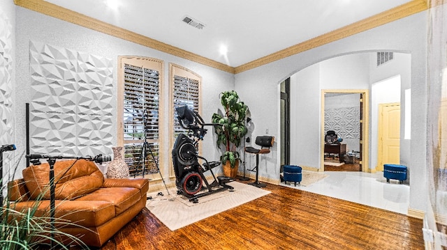 exercise area featuring ornamental molding and dark hardwood / wood-style flooring