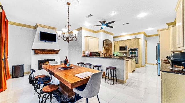 dining space with ceiling fan with notable chandelier, light tile floors, and crown molding