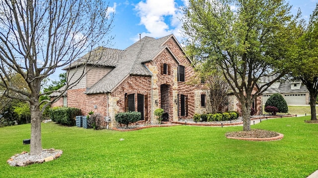 view of front of house with a front lawn, a garage, and central air condition unit