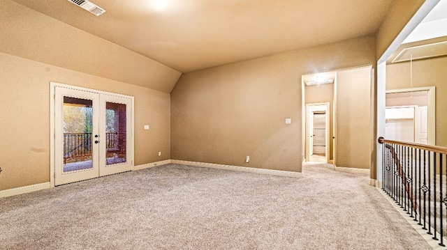 carpeted spare room featuring french doors and lofted ceiling