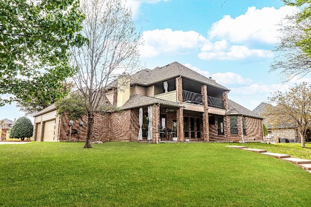 view of front of property featuring a balcony, a garage, and a front yard