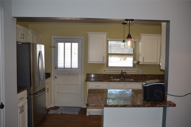 kitchen with stainless steel refrigerator, white cabinets, sink, dark hardwood / wood-style floors, and hanging light fixtures