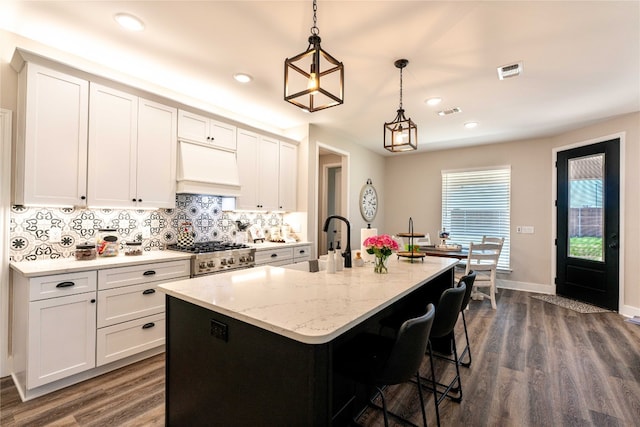 kitchen featuring dark hardwood / wood-style flooring, decorative light fixtures, stove, and white cabinetry